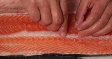 Deboning fresh salmon for a delicious Sushi snack - close up slowmo video