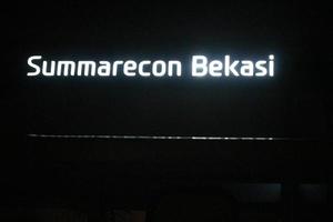 Bekasi, Indonesia in July 2022. The Summarecon bekasi logo shining brightly at night against the dark night sky. photo