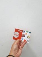 West Java, Indonesia in January 2023. Isolated white photo of a hand holding the KAKOO product brand tag