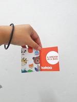 West Java, Indonesia in January 2023. Isolated white photo of a hand holding the KAKOO product brand tag