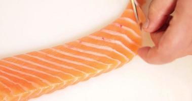 capocuoco sfilettatura un' fresco salmone per Sushi piatto su un' chopping tavola. - vicino su tiro video