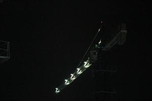 grúa torre trabajando de noche. la iluminación no es demasiada, foto