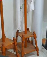 Photo of an indoor flagpole stand made of wood. It has four legs as a solid base so it doesn't fall easily.