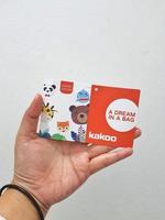 West Java, Indonesia in January 2023. Isolated white photo of a hand holding the KAKOO product brand tag