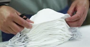 Hands Of Seamstress Piling Up White Cloth Masks - Closeup Shot Slow Motion video