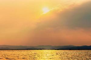 Sun shines golden in the clouds at summer photo