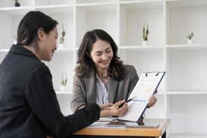 dos líderes empresariales hablan de gráficos, gráficos financieros que muestran resultados que analizan y calculan estrategias de planificación, procesos de creación de éxito empresarial foto