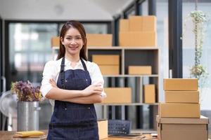 Portrait of young Asian woman working SME with a box at home the workplace.start-up small business owner, small business entrepreneur SME or freelance business online and delivery concept. photo