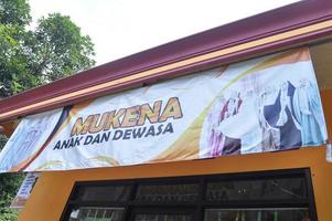 Gresik, Indonesia, 2022 - mukenah shop banner hanging in front of the shop building photo