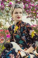 Close up elegant woman with small puppy in blooming garden portrait picture photo