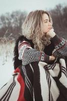 Close up pretty woman with warm blanket in snowy field portrait picture photo