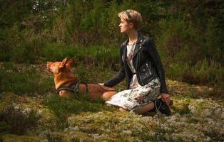 dama de pelo corto con perro en fotografía escénica del parque foto