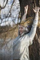 Close up relieved woman with willow crown stretching arms up portrait picture photo