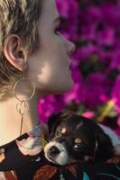 Close up puppy on shoulder of young woman in garden portrait picture photo