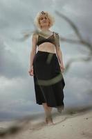 Smiling woman walking along sand beach scenic photography photo