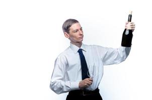 hombre de negocios con una copa y una botella de vino en las manos sobre un fondo blanco y aislado foto