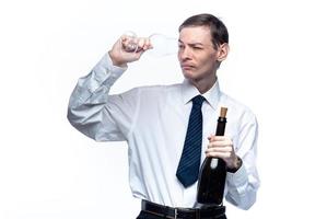 hombre de negocios con una copa y una botella de vino en las manos sobre un fondo blanco y aislado foto