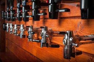 Beer taps for draught drinks are built into wooden boards photo