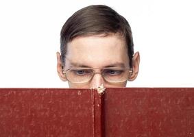 The man's face is covered by a large red notebook, on an isolated background photo