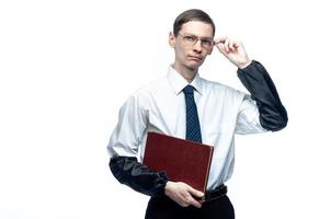 un hombre de negocios con corbata y gafas con una revista en las manos sobre un fondo blanco y aislado foto