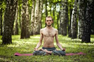 Yoga man meditating at sunset. Male model of meditation in serene harmony photo