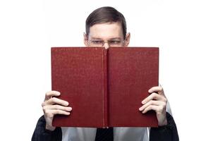 The man's face is covered by a large red notebook, on an isolated background photo