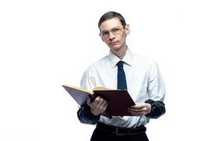 un hombre de negocios con corbata y gafas con una revista en las manos sobre un fondo blanco y aislado foto