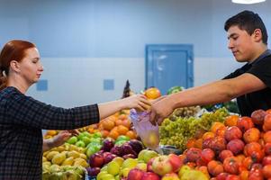 mujer comprando verduras frescas en el mercado callejero. foto