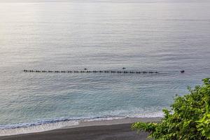 Lazy guys on a canoe trip getting towed by a motorboat on the east shore of Taiwan in summer photo