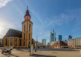 View over the square at the Hauptwache in Frankfurt with St. Catherine's Church and skyscrapers of the skyline in morning light photo