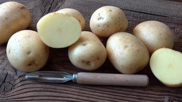 pommes de terre sur la planche de bois. pomme de terre fraîche sur fond rustique video