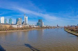 Panoramic picture from pedestrian bridge Holbeinsteg in Frankfurt over Main river and skyline with blue sky and sunshine photo