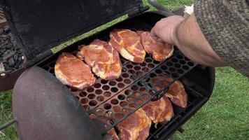 rohe Schweinesteaks auf dem Grill mit Gewürzen video