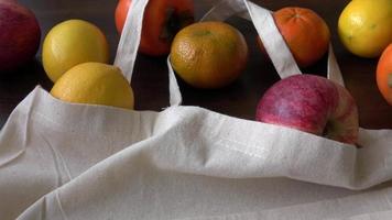 eco väska med Produkter frukter. noll avfall använda sig av mindre plast begrepp. färsk frukt organisk i eco bomull tyg påsar på trä- tabell video