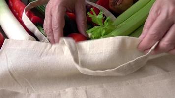 bolsa ecológica con productos vegetales. cero desperdicio use menos concepto de plástico. verduras frescas orgánicas en bolsas de tela de algodón ecológico sobre mesa de madera video