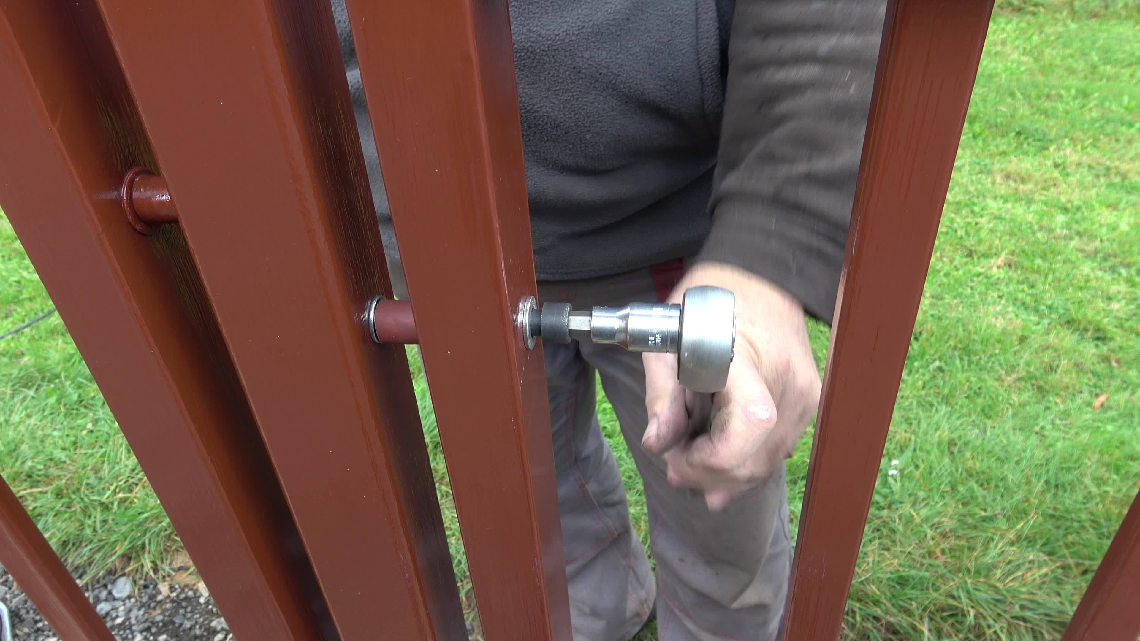 Building a metal fence with a screwdriver and screw. Close up of his