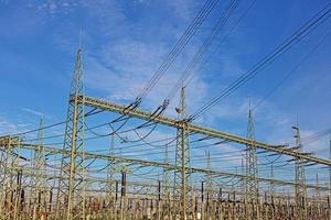 Picture of a transformer station with many insulators and cables during the day photo