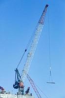 Close up picture of tower crane on top of highrise building construction site in Dubai photo