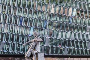 Sculpture in front of concert hall in Reykjavik with impressive glass facade photo