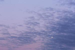 Image of full moon against colorful evening sky with light clouds photo