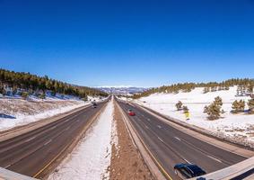 View on highway with Rocky Mountains in the background in winter photo