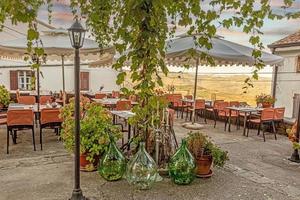 View from an overgrown and decorated terrace in Motovun over the surrounding countryside during the day photo