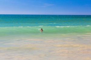 persona nadando en aguas turquesas en la costa del algharve en portugal en verano foto