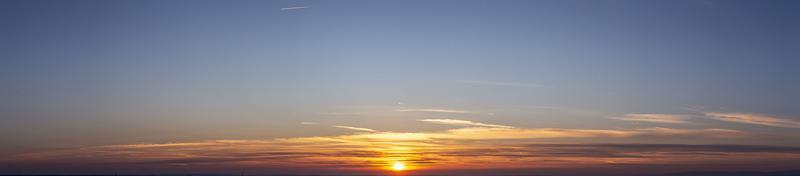 imagen de cielo dramático y colorido con sol durante la puesta de sol foto