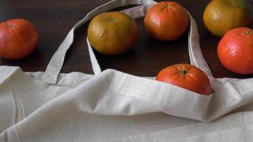 sac écologique avec produits fruits. zéro déchet utilise moins de concept de plastique. fruits frais bio dans des sacs en tissu de coton écologique sur table en bois video