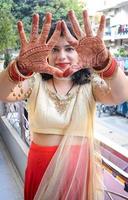 hermosa mujer vestida como tradición india con diseño de henna mehndi en ambas manos para celebrar el gran festival de karwa chauth, celebraciones de karwa chauth de una mujer india para su marido foto