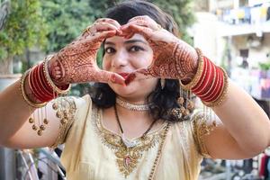 hermosa mujer vestida como tradición india con diseño de henna mehndi en ambas manos para celebrar el gran festival de karwa chauth, celebraciones de karwa chauth de una mujer india para su marido foto