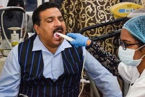 delhi, india - 19 de noviembre de 2022 - primer plano de una dentista haciendo un chequeo dental de rutina al paciente, paciente acostado en una silla en el chequeo anual de salud, dentista haciendo un chequeo dental al paciente foto