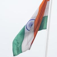 India flag flying high at Connaught Place with pride in blue sky, India flag fluttering, Indian Flag on Independence Day and Republic Day of India, tilt up shot, Waving Indian flag, Har Ghar Tiranga photo