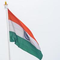 India flag flying high at Connaught Place with pride in blue sky, India flag fluttering, Indian Flag on Independence Day and Republic Day of India, tilt up shot, Waving Indian flag, Har Ghar Tiranga photo